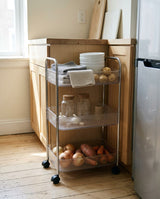 Rolling storage cart beside a kitchen counter